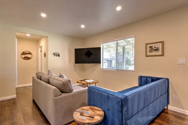 Cottage #66 at Tahquitz Pines Retreat, a living room with a gray sofa, a blue velvet sofa and a wall-mounted TV