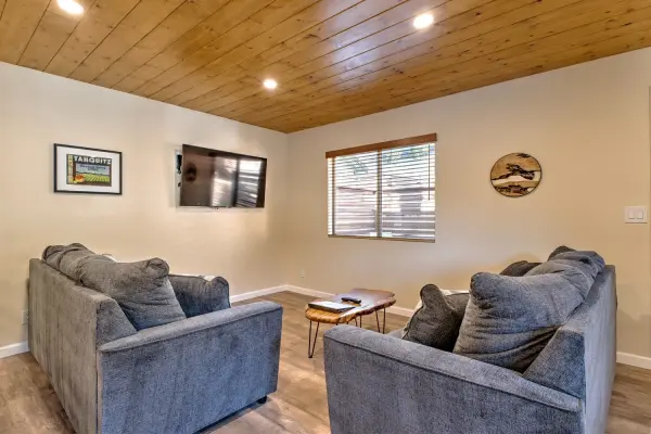 Cottage #71 at Tahquitz Pines Retreat, a sitting room with two gray sofas, a live-edge coffee table and a pine ceiling