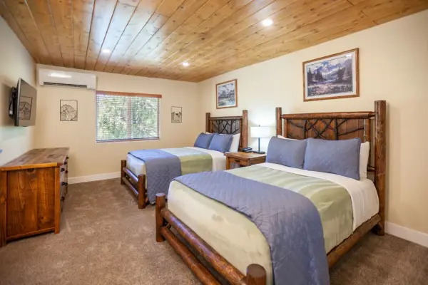 Economy 2 Fulls at Tahquitz Pines Retreat, two full beds with twig log headboards under a pine plank ceiling