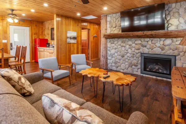 Executive 2 Bedroom at Tahquitz Pines Retreat, a living room with a river rock fireplace, live-edge tables and a kitchen