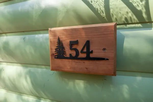 Executive 3 Bedroom at Tahquitz Pines Retreat, a wooden unit sign reading 54 with a pine tree cutout on green siding