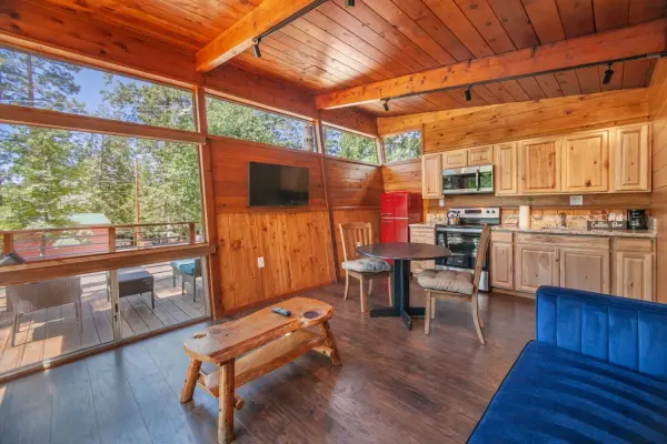 Executive Queen at Tahquitz Pines Retreat, a kitchenette with a red fridge and dining table beside windows onto a deck