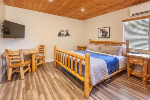 Family King at Tahquitz Pines Retreat, a king log bed with a log dining set, wall TV and a bear painting