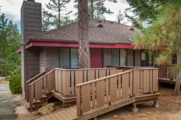 New Rustic Cabin, 1 Bedroom at Idyllwild Inn, a shingled cabin with a red door and a wooden deck with an access ramp