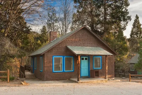 Rustic Cabin, 2 Bedroom at Idyllwild Inn, a brown shingled cabin with blue trim, a turquoise door and a brick chimney