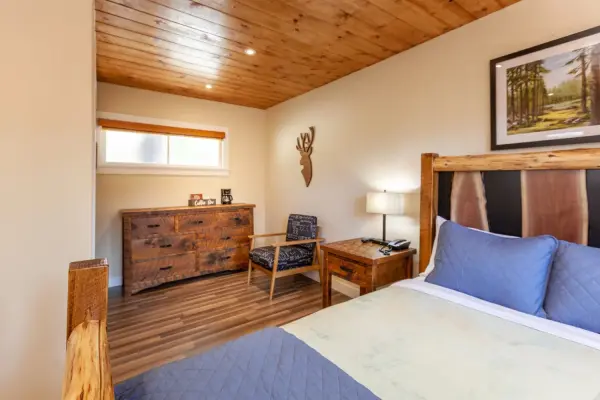 Rustic Queen at Tahquitz Pines Retreat, a queen bed with a live-edge wood headboard, rustic dresser and armchair