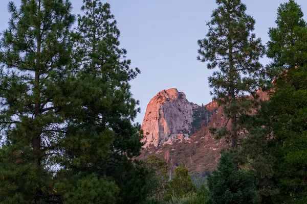 Tahquitz Rock glowing pink in the evening light above the pines in Idyllwild
